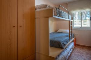 Litera en habitación pequeña con cama en AT052 Planta baja con piscina, tan solo 600m de la playa, en Torredembarra