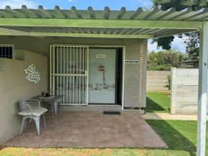 a patio with a table and chairs under a pergola at The Lighthouse Guesthouse in Welkom