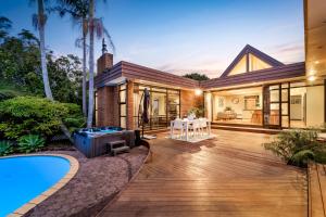uma casa com um deque e uma piscina em Entire house with pool, spa em Auckland