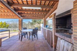 een patio met een tafel en stoelen en een open haard bij Can Tarana in Santa Cristina d'Aro
