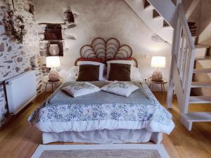 a bedroom with a bed with two lamps and a staircase at Manoir le Courtillon in Le Pont Réan