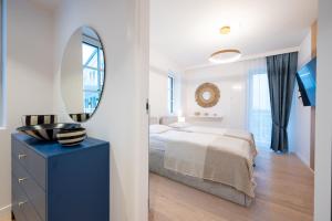 a white bedroom with a bed and a mirror at Marina Royale Darłowo - Apartamenty Vista Mar nad morzem in Darłowo