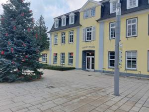 a christmas tree in front of a yellow building at Fewo Grünberg in Bad Nenndorf