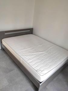 a bed in a room with a white mattress at Appartement - Vendôme in Vendôme