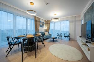 een woonkamer met een tafel en stoelen en een bank bij Marina Royale Darłowo - Apartamenty Vista Mar nad morzem in Darłowo