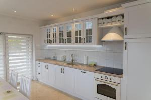 a kitchen with white cabinets and a sink at VacationClub - Ochorowicza 3E VacationHome in Wisła