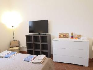 a bedroom with a bed and a tv on a dresser at Empoli Campagna, Appartamento Indipendente con giardino 500 mq e piscina privati in Empoli