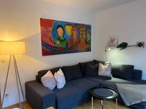 a living room with a blue couch and a painting at BELIEBT Zentrales & ruhiges Innenstadtapartment in Halle an der Saale