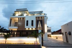 a house with lights on the front of it at 2-BEDRM URBAN Elegance at The Rosedale Apartments in Accra