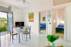 a dining room with a table and chairs and a bedroom at !!! 2 MIN DALLA SPIAGGIA !!! - Casa Vacanze Coralli in Sciacca