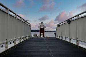 a dock with a lighthouse in the middle of the water at Ralph's Haus am See in Plau am See