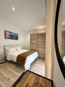 a bedroom with a large bed and a wall at Tan-Nanniet Two Bedroom Apartment in Marsaxlokk