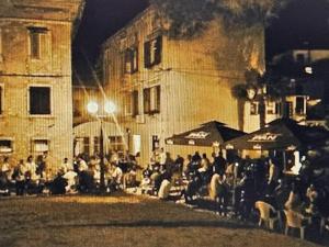 Une foule de personnes assises devant un bâtiment la nuit dans l'établissement Ferienglück unterm Dach, à Poreč