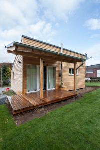 a small wooden house with a large deck at Ferienhaus Eifeltraum Magma in Berlingen