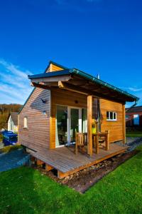 a small wooden cabin with a table on a deck at Ferienhaus Eifeltraum Magma in Berlingen