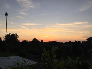 a sunset over a city with a church in the distance at Ferienhaus Eifeltraum Magma in Berlingen