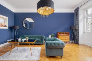ein Wohnzimmer mit blauen Wänden und einer grünen Couch in der Unterkunft Luxury Apartment with Two Bedrooms and Balcony by Renters Prestige in Krakau
