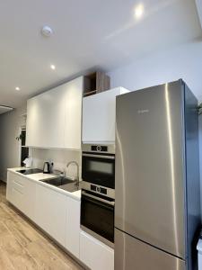 a kitchen with a stainless steel refrigerator and a sink at Tan-Nanniet Two Bedroom Apartment in Marsaxlokk