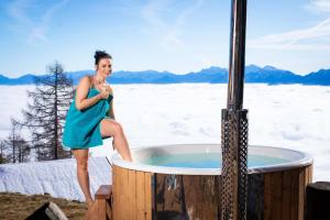 a woman in a blue dress standing next to a hot tub at Chalet Petit in Kanzelhöhe