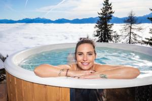 a woman laying in a hot tub in the snow at Chalet Petit in Kanzelhöhe