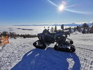 a snowmobile parked in the snow on a mountain at Chalet Petit in Kanzelhöhe