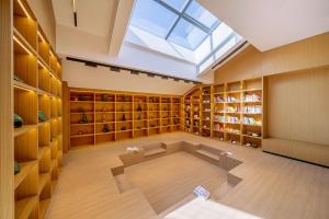 uma clarabóia num quarto com prateleiras de madeira e um quarto amplo com em Beijing Land of Arts and Crafts em Pequim