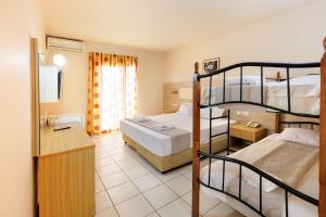 a hotel room with two bunk beds and a desk at Aqua Sun Village in Hersonissos