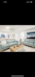 a living room with two blue couches and a table at Beach home in the heart of Agnes in Agnes Water