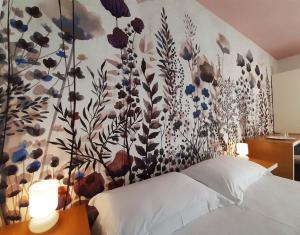 a bedroom with a flower mural on the wall at Hotel Grecale in Porto Cesareo