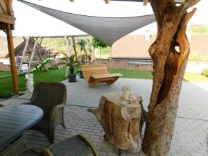 a patio with a tree stump and a table and chairs at Trudis Ferienwohnung in Veringendorf