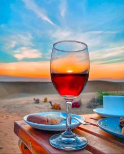 un verre de vin assis au-dessus d'une table dans l'établissement Desert Malra Camp, à Jaisalmer