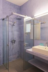 a bathroom with a glass shower and a sink at Pasithea Suites in Monemvasia