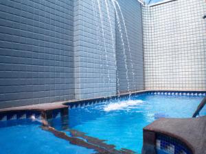 a large swimming pool with a water fountain at Cartago Hotel in Rio de Janeiro