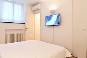 ein Schlafzimmer mit einem weißen Bett und einem TV an der Wand in der Unterkunft Angy's House in Santa Margherita Ligure