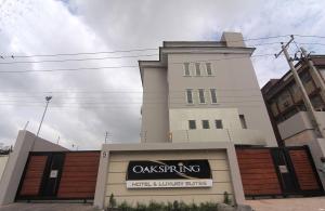 un edificio blanco con un cartel delante en Oakspring Hotel and Luxury Suites, en Lagos
