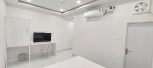 a white room with a tv on a wall at Planet Star Homestay in Bikaner