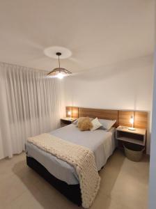 ein Schlafzimmer mit einem großen Bett und zwei Nachttischen in der Unterkunft Hermoso Departamento confort y calidad in Cordoba