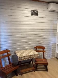 dwie ławki i stół przed ścianą w obiekcie La Casita w mieście Tacuarembó