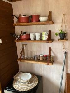 una cocina con estanterías de madera, ollas y sartenes en La Casita, en Tacuarembó