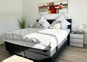 ein Schlafzimmer mit einem großen Bett mit weißer Bettwäsche und Kissen in der Unterkunft Exklusive Wohnung mit Ahrblick 2, Balkon und 2 Schlafzimmer in Bad Neuenahr-Ahrweiler