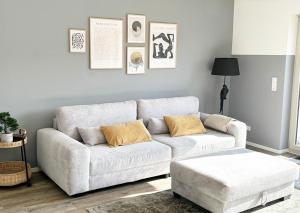 ein Wohnzimmer mit einem weißen Sofa und einem Tisch in der Unterkunft Exklusive Wohnung mit Ahrblick 2, Balkon und 2 Schlafzimmer in Bad Neuenahr-Ahrweiler