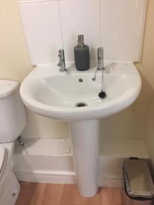 a white sink in a bathroom with a toilet at Moonbay apartment in Cardiff