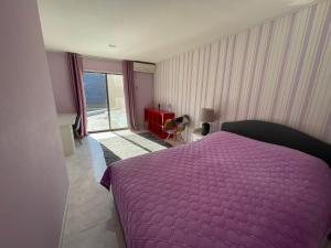 um quarto com uma cama roxa e uma grande janela em near shibuya quiet residential area em Tóquio