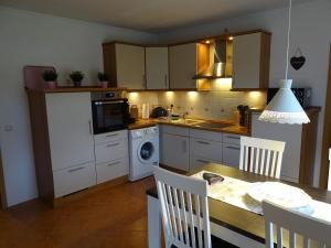 uma cozinha com uma mesa e uma cozinha com uma placa de fogão. em BlüteNo1 mit Sauna, Kamin und Garten em Wiesmoor