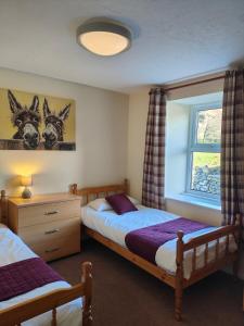 a bedroom with two twin beds and a window at Holiday Cottage 7 in Watermillock