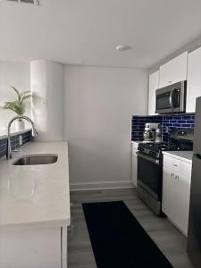 a white kitchen with a sink and a stove at MEB Loft in Darby