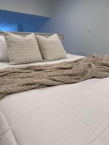 een wit bed met witte lakens en kussens bij MEB Loft in Darby