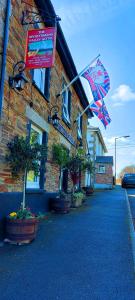 a building with a flag and a sign on it at Sportsmans Valley Hotel in Liskeard