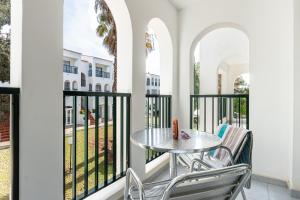 a patio with a table and chairs on a balcony at Vibra Caleta Playa Apartmentos-3SUP in Sa Caleta