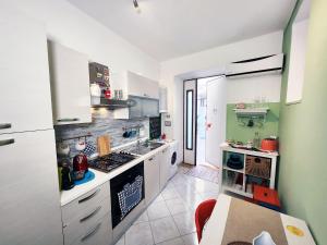 バーリにあるArco Alto Apartmentの緑の壁、白い家電製品付きのキッチン